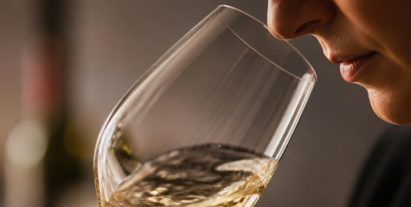 Close-up van iemand die ruikt aan een glas wijn
